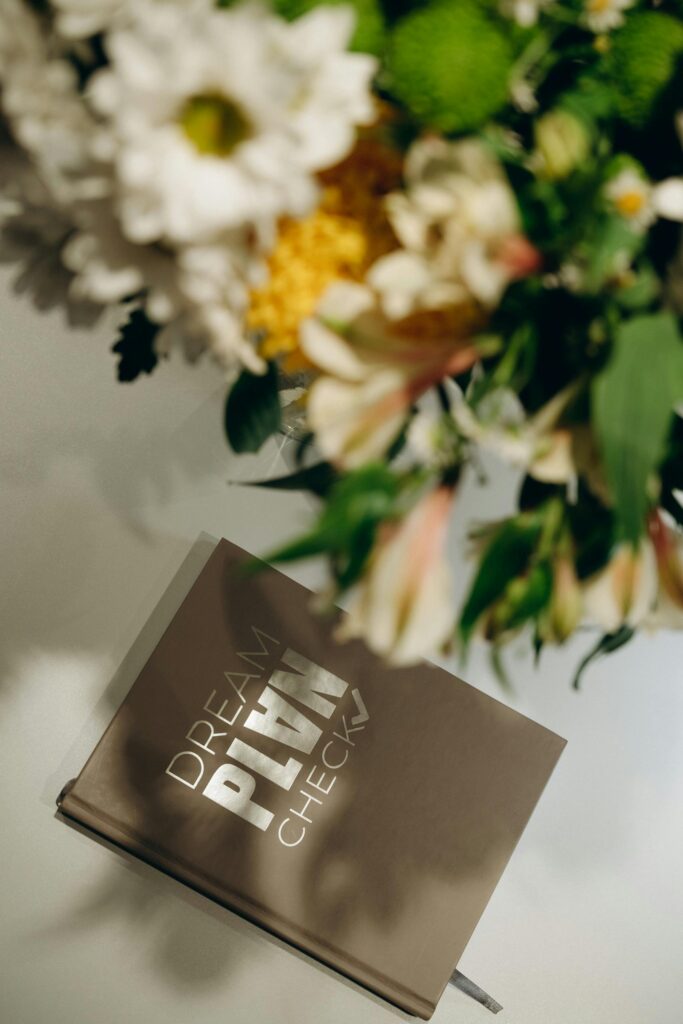Elegant floral bouquet beside a 'Dream Plan Check' planner, ideal for creative planning.